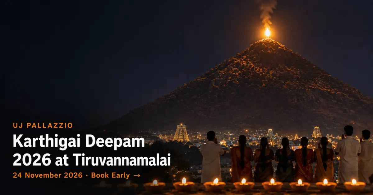 The Maha Deepam flame lit atop Arunachala Hill on Karthigai Deepam night, with the Arunachaleswarar Temple gopurams and Tiruvannamalai town lit below and devotees watching beside rows of oil lamps