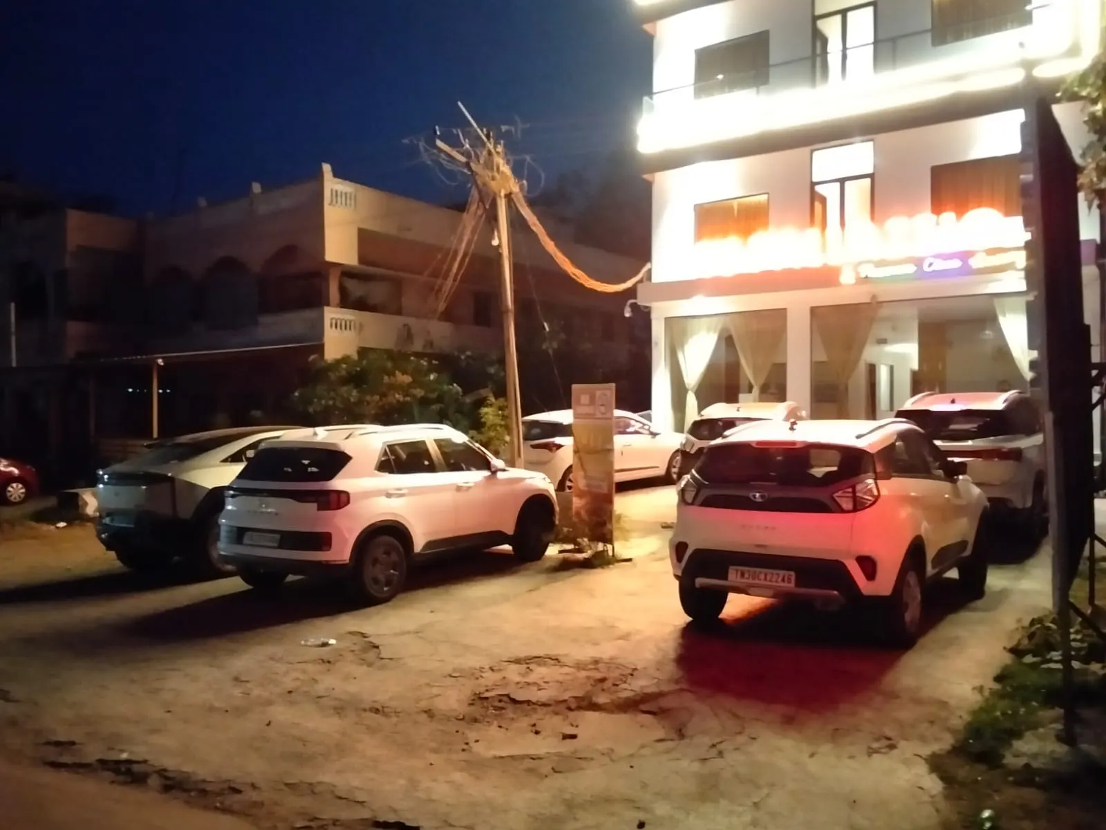 Cars parked outside UJ Pallazzio at night, a hotel with free secure parking near Arunachaleswarar Temple, Tiruvannamalai